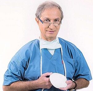 the doctor holds the implant for breast augmentation